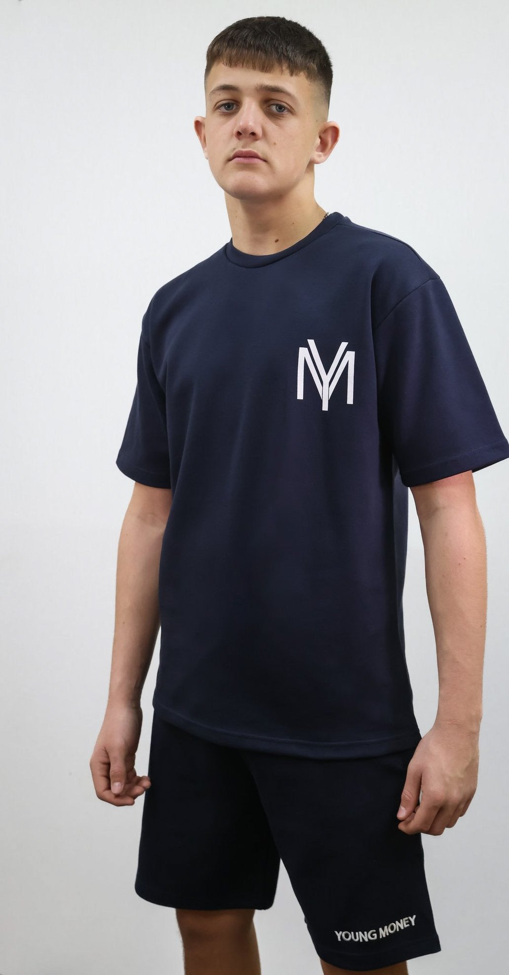 Navy relaxed fit T-shirt and shorts set with printed YM logo and embroidered young money text on a male model size medium