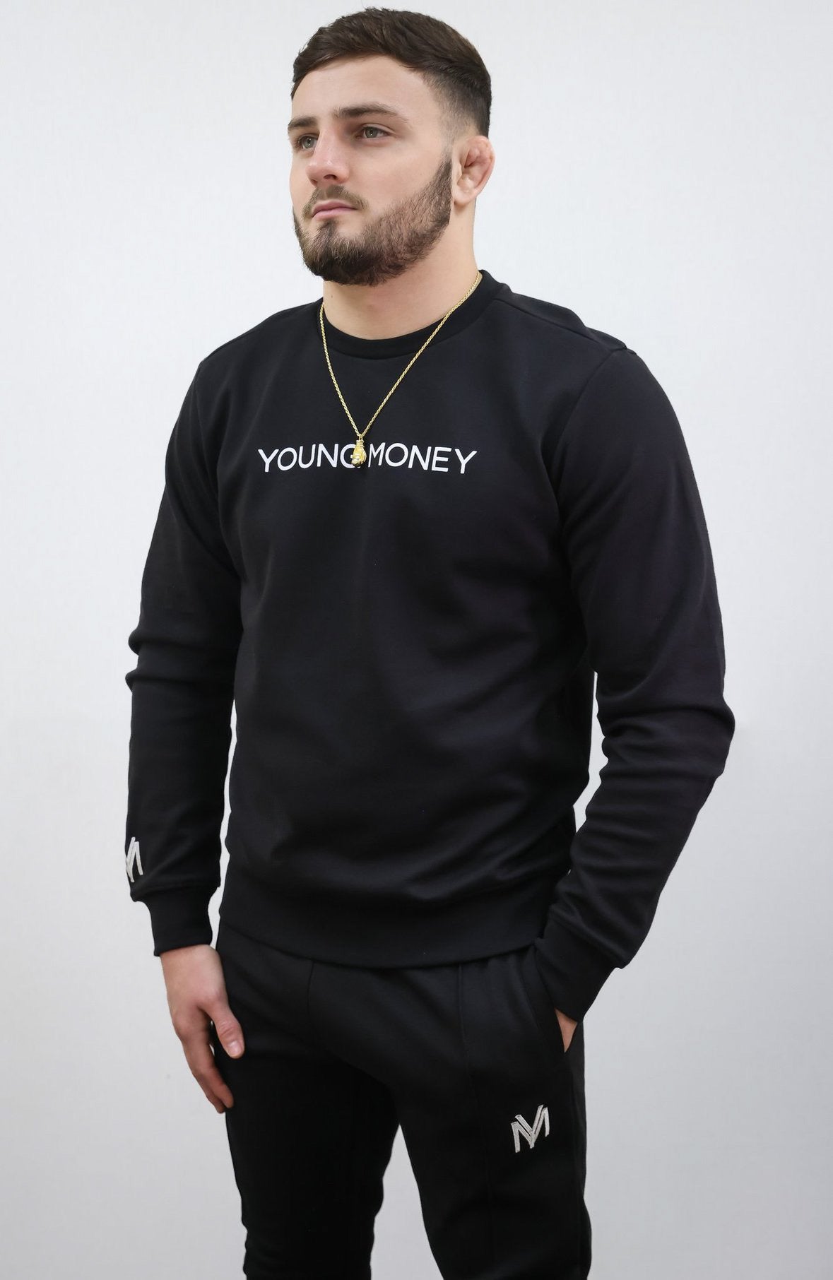 Slim fit tracksuit in black featuring the sweatshirt and joggers on a male model size medium