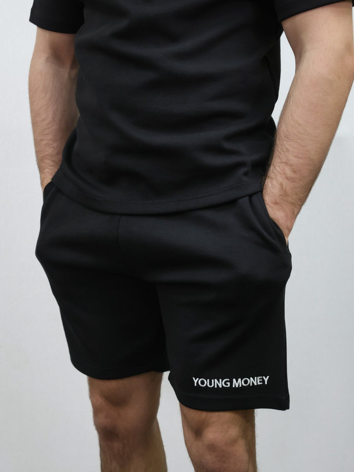 Black relaxed fit shorts with embroidered young money text on a male model with matching T-shirt set size medium