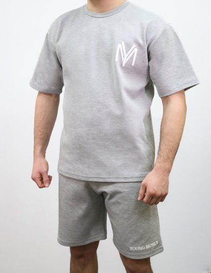 Grey relaxed fit shorts and T-shirt set with embroidered young money text and printed logo on a male model size medium