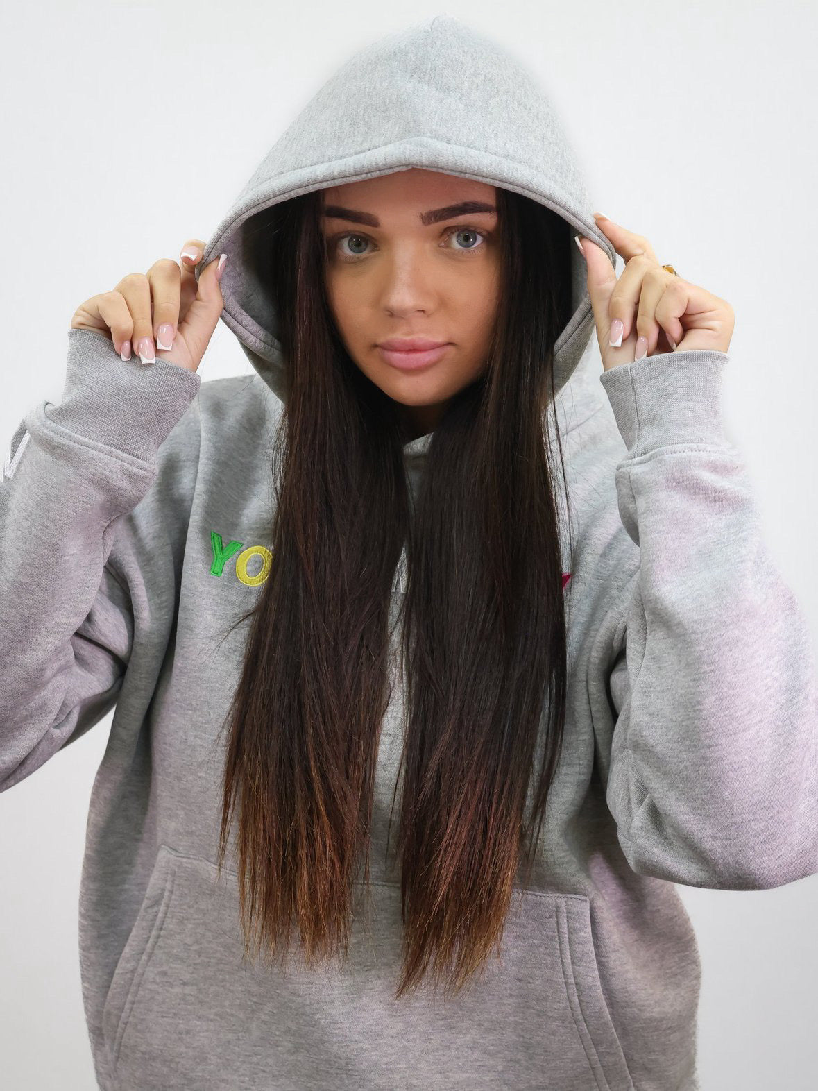 Grey hoodie with a direct embroidered young money text in illuminous multicolours on a female model size small