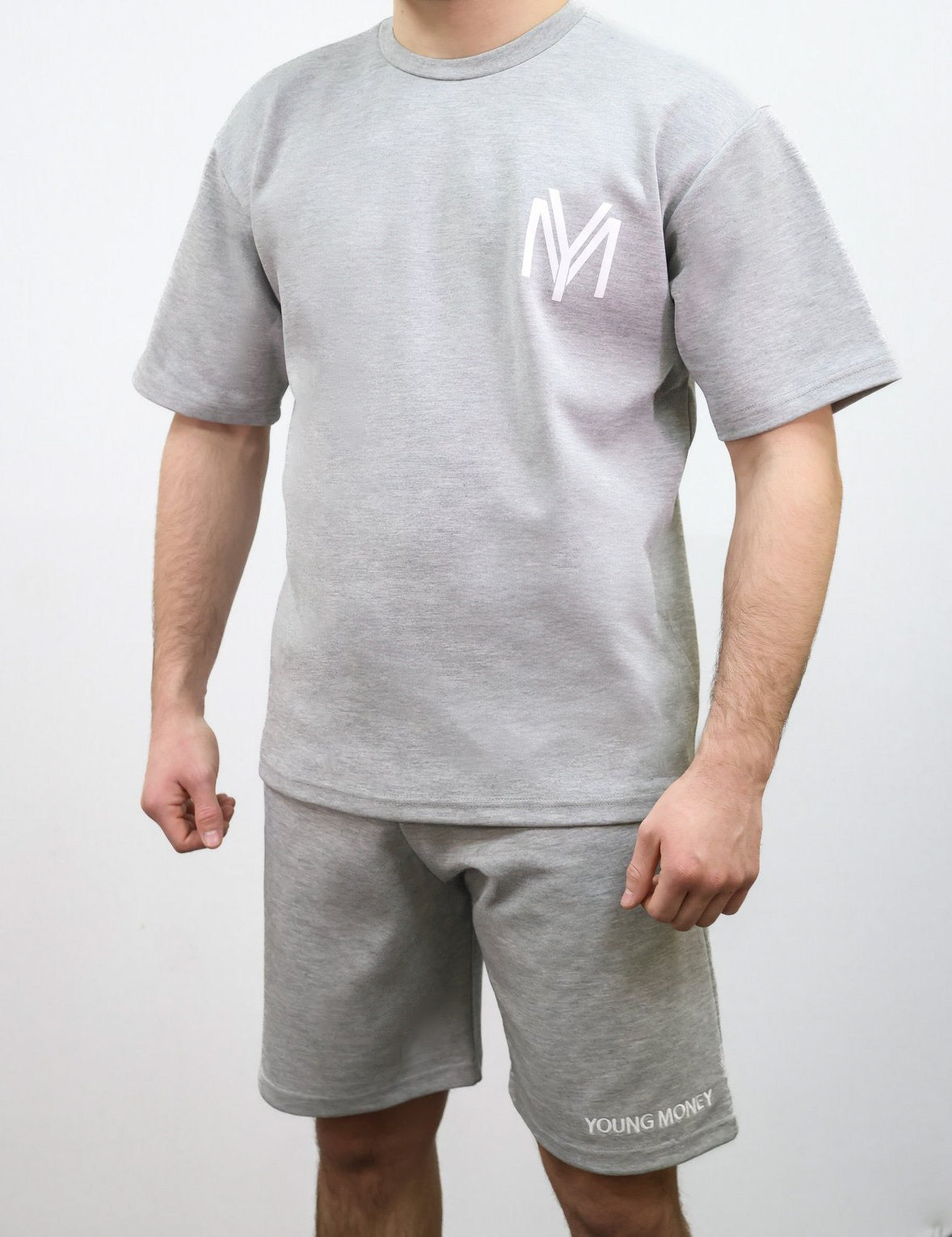 Grey relaxed fit T-shirt and shorts set with printed YM logo and embroidered young money text on a male model size medium