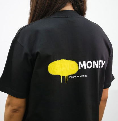 Black organic cotton oversized T-shirt with a yellow spray paint graphic on the back on a female model size XS