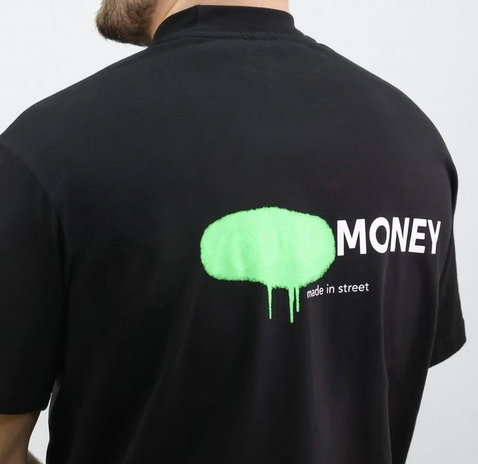 Black organic cotton oversized T-shirt with a green spray paint graphic on the back on a male model size medium