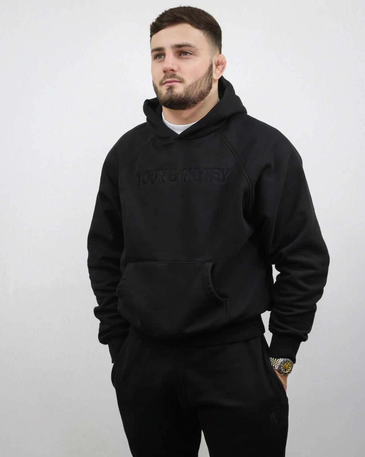 Premium organic cotton black tracksuit featuring the hoodie and joggers on a male model size small