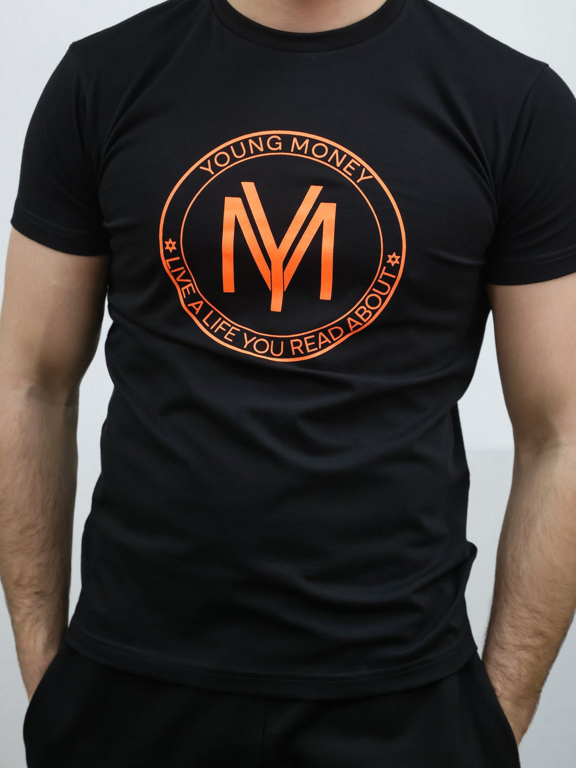 Black slim-fit T-shirt with a coloured shield design across the front with the brand's slogan in orange on a male model size medium