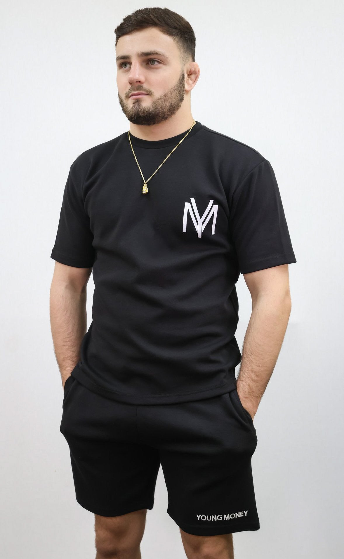 Black relaxed fit T-shirt and shorts set with printed YM logo and embroidered young money text on a male model size medium