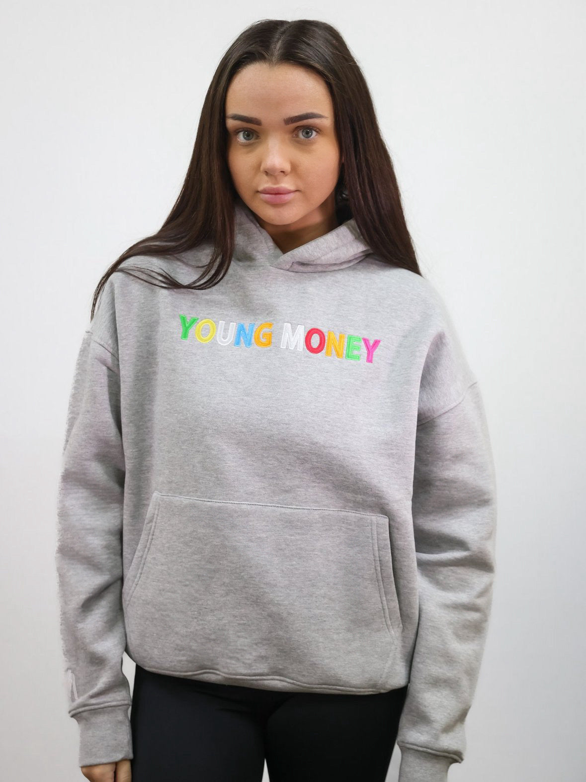 Grey hoodie with a direct embroidered young money text in illuminous multicolours on a female model size small